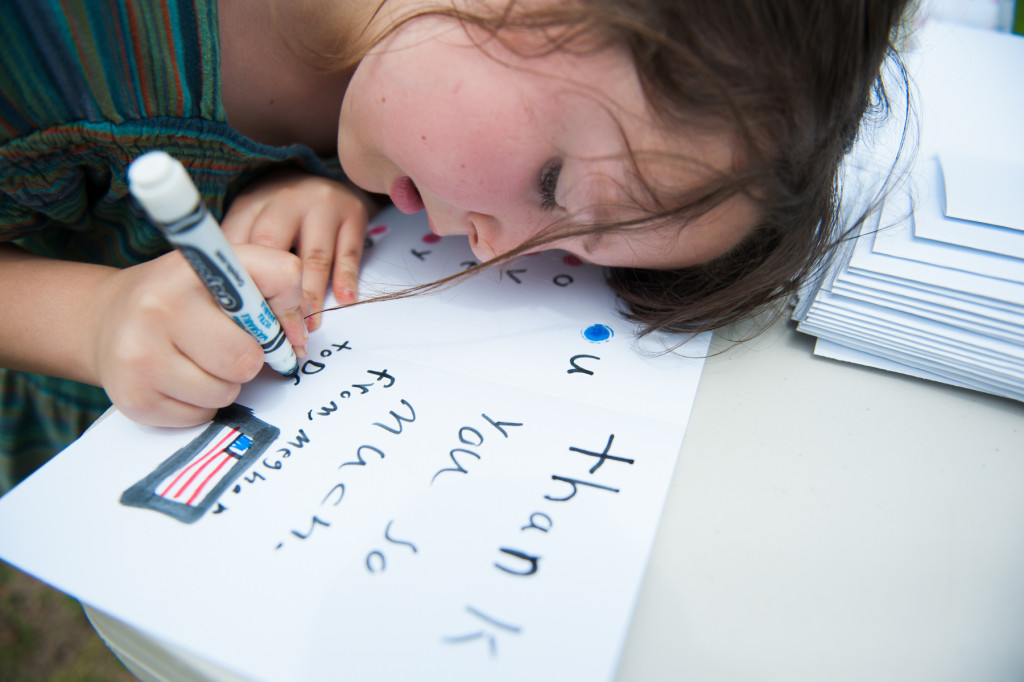 Seven-year-old Meghan Kane writes "Thank you so  much" in the card she makes for her father during the Fifth annual Celebration of the Military Child, sponsored by the Kiwanis Club of the Sandhills in partnership with the Village of Pinehurst, at the Arboretum Park on Saturday, April 18, 2015 in Pinehurst, North Carolina.  Kane said she will give it to her father when he comes home.