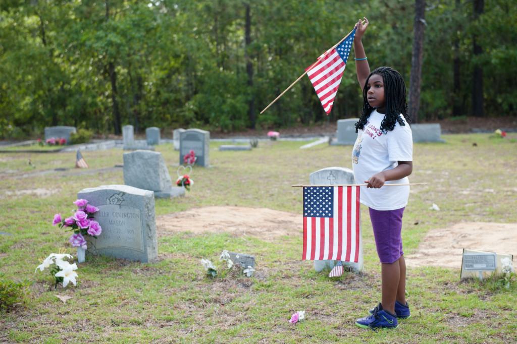 Eight-year-old Amauri Chalmners of Southern Pines points to veterans graves at the Woodlawn Cemetery on Friday, May 22, 2015 in Southern Pines, North Carolina.