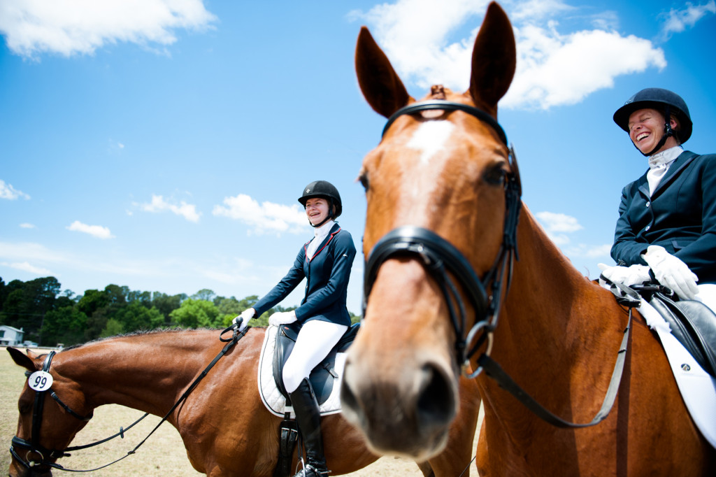 Lisa Wall (right), of Apex, sits on her horse Baaron Miller Rh as she smiles and laughs with her daughter Olivia Wall (left), who's sitting on her horse Mandolin R, as they wait for their scheduled riding times during the Dressage in the Sandhills Horse Show at the Pinehurst Harness Track on Friday, May 8, 2015 in Pinehurst, North Carolina.