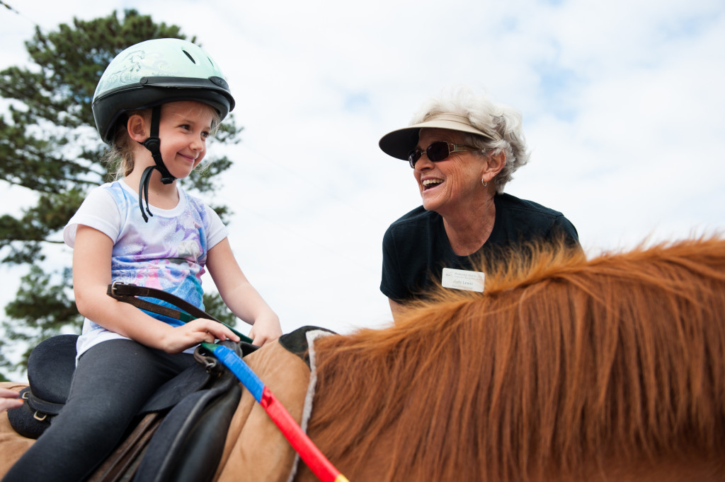 Five-year-old Emmylyn Justin smiles to Judy Lewis after she got on Funny all by herself during a Prancing Horse show at Muddy Creek Farm off Trails End Road on Thursday, May 14, 2015 in Whispering Pines, North Carolina.