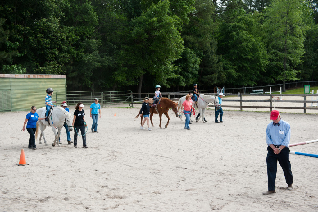 Show judge Bill Lewis (far right) walks to the rail so he can watch the group's riding pattern during a Prancing Horse show at Muddy Creek Farm off Trails End Road on Thursday, May 14, 2015 in Whispering Pines, North Carolina.