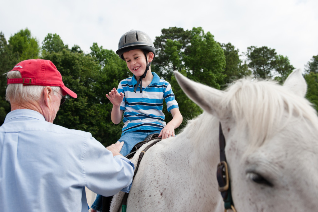 Nine-year-old Joseph Strobel smiles with show judge Bill Lewis (left) as he receives his awards after placing during a Prancing Horse show at Muddy Creek Farm off Trails End Road on Thursday, May 14, 2015 in Whispering Pines, North Carolina.