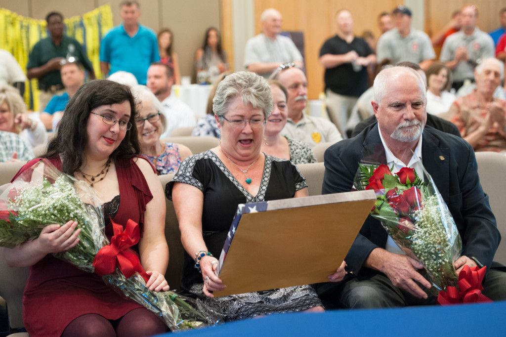 Marlene Thomas laughs after she receives a canvas picture of her husband Floyd Thomas (right) during his retirement ceremony as Deputy Chief of the Pinehurst Police Department at Village Hall on Thursday, June 26, 2015 in Pinehurst, North Carolina.