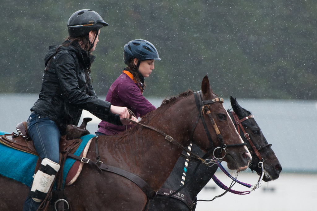 Fifteen-year-old Hannah Johnson rides Cami with 13-year-old Faith Kane (background) on Ebony as they work around barrels in the rain for practice on Saturday, October 10, 2015 at the Harness Track and Fair Barn in Pinehurst, North Carolina. The girls with the Central Carolina Barrel Racers were going to perform demonstrations for the Annie Oakley Boom Day event, but with the rain keeping most spectators away, the group decided to practice for the State Fair.