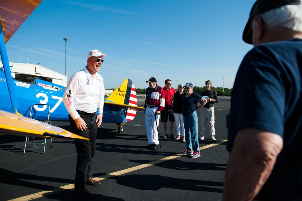 Founder, President and Pilot of Ageless Aviation Darryl Fisher laughs with the group of people from the Southern Pines Gracious Living Retirement Community before taking guests on rides in his Boeing Stearman biplane at the Moore County Airport on Tuesday, September 1, 2015 in Whispering Pines.