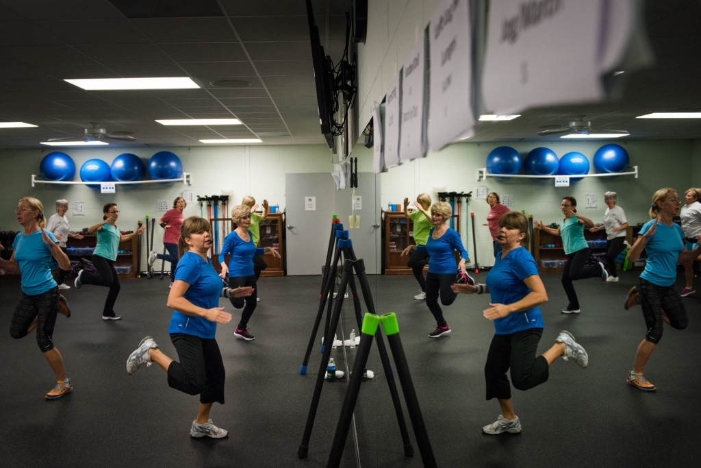 Esther Zollman (center, left) a fitness instructor, leads a Tabata class in the reflection of a large mirror in a work-out room at the Senior Enrichment Center on Monday, November 23, 2015 near West End, North Carolina. Tabata is a high-intensity work-out, followed with short rest periods.