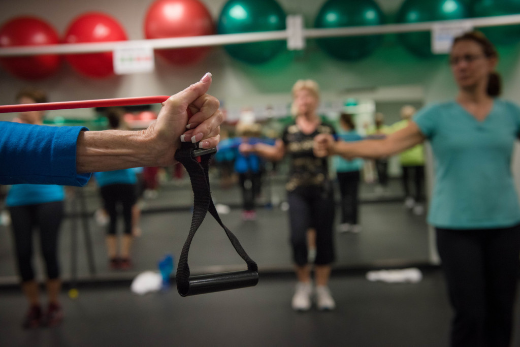 Cathy Miles stretches with an elastic rope during a Tabata class at the Senior Enrichment Center on Monday, November 23, 2015 near West End, North Carolina.